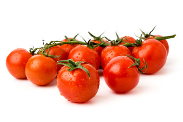 Ripe cherry tomatoes with water drops on a white background.