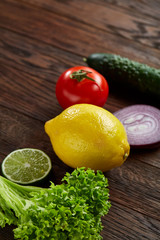Still life of fresh organic vegetables on wooden plate over wooden background, selective focus, close-up