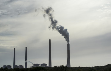 Power plant stacks with smoke, on evening sky background