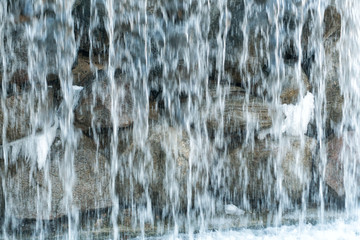 Fototapeta na wymiar Artificial waterfall spring water flows into the lake