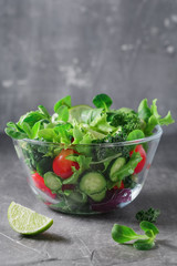 Fresh vegetable salad over textured grey background. The concept of organic vegetarian food. Copy space.