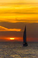 USA, Florida, Amazing orange sunset sky with sailboat on ocean water
