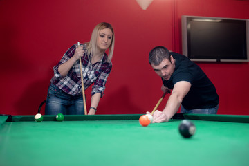 Boy and girl are playing pool