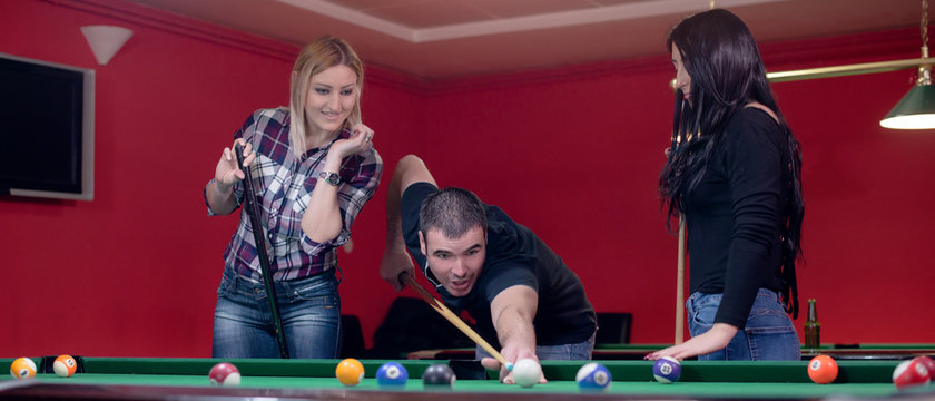 Three friends are playing pool