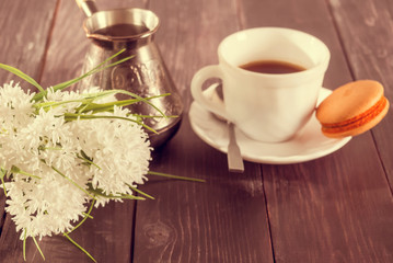 Morning surprise. Coffee, macaroni on a saucer and a bouquet of flowers