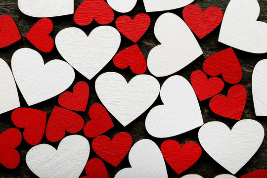 Red and white wooden hearts on grey table