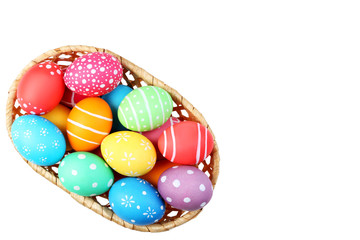 Fototapeta premium Colorful easter eggs in basket isolated on white background