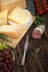 Cheeses with basil, rosemary, tomatoes, grapes and salame.