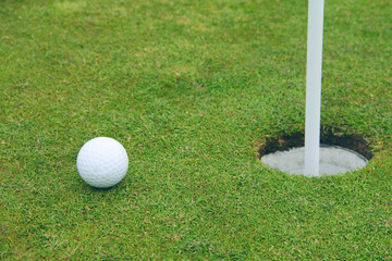 Golf ball on lip of cup