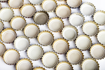 many inverted covers of beer are laid out in rows, the background