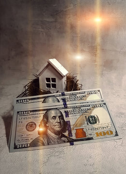 Buying, selling a house, a white house in a nest on the background of dollars at sunset. Your house is an investment.