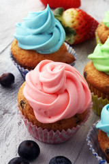 Obraz na płótnie Canvas Tasty cupcakes on wooden background. Birthday cupcake in rainbow colors