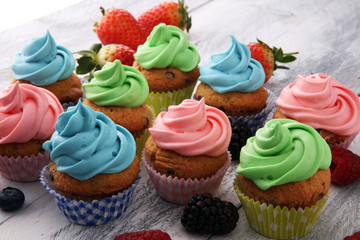 Tasty cupcakes on wooden background. Birthday cupcake in rainbow colors