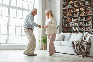 Senior couple together at home retirement concept dancing active dance step forward