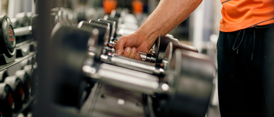 Fototapeta na wymiar Muscular arm picking up weights