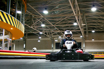 The man is in the go-kart on the karting track - obrazy, fototapety, plakaty