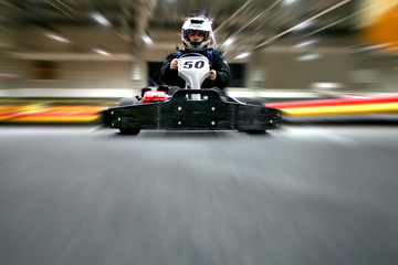 The man is in the go-kart on the karting track - obrazy, fototapety, plakaty