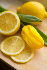 Obraz na płótnie Canvas Лимон и желтый тюльпан на доске 