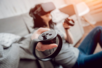 The beautiful girl playing games with virtual reality goggles