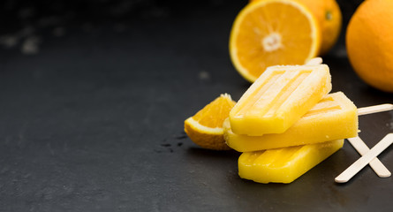 Homemade orange popsicles on a vintage background (selective focus)