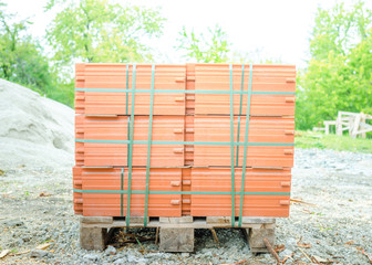Ceramic roof shingles on a stack on a construction site on a bright suunny day