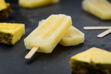 Portion of Pineapple Popsicles on a slate slab (selective focus; close-up shot)