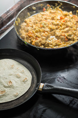 Cooking burrito in a pan with chicken, pepper, tomato for fajitas typical .Latin America food