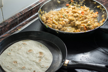Cooking burrito in a pan with chicken, pepper, tomato for fajitas typical .Latin America food