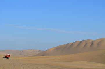 Fototapeta na wymiar Buggy at sand dunes in Huacachina desert, Ica, Peru