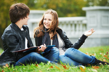 Happy college students on campus lawn outdoors