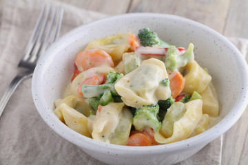 Tortellini with vegetables under cream sauce
