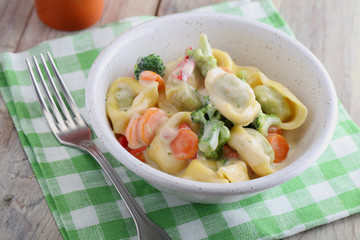 Tortellini with vegetables under cream sauce