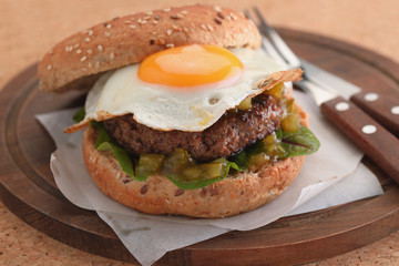 Hamburger with fried egg and gherkin salad