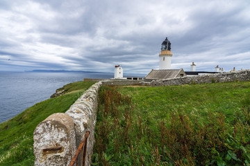 Fototapeta na wymiar Dunnet Head lighthouse on Pentland Firth with Orkney on the background, Scotland north coast, Britain