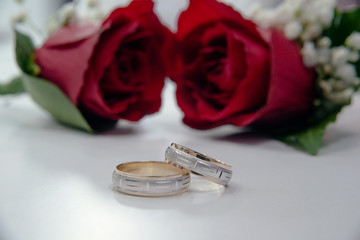 Wedding rings and red roses.