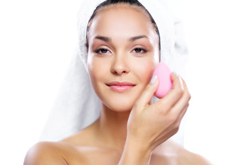 Woman using special sponge on her face.
