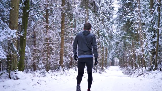 Jogger walking in the forest in winter