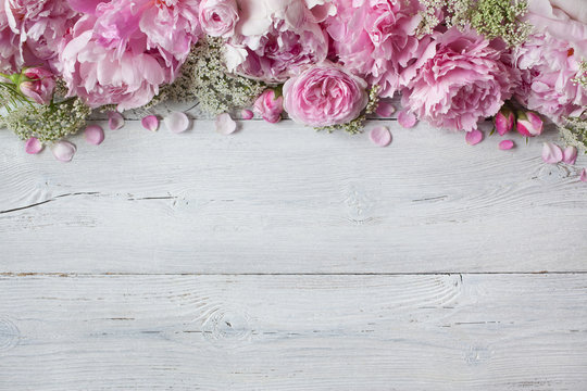 Fototapeta Pink peonies and roses on a white wooden background, space for text