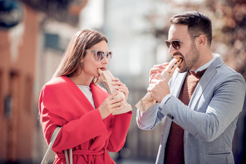 Happy couple eating sandwich and having a great time