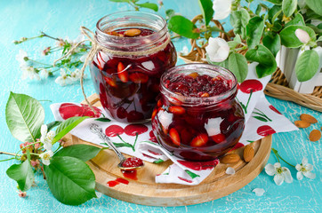 Cherry jam with apple and almonds on a blue background