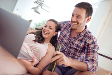 Young couple relaxing on the couch with laptop