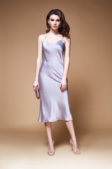Sexy beauty woman pretty face tan skin wear lilac silk dress long skinny body shape makeup cosmetic summer collection studio catalog brunette curly hair clothes for date meeting walk party fashion.