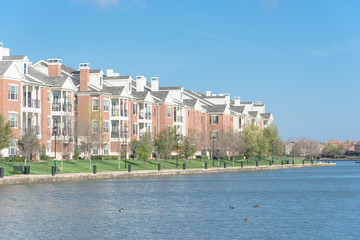 Typical lakeside apartment building complex at Las Colinas, Irving, Texas. Cloud blue sky birds , ducks swimming in front. © trongnguyen