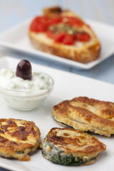 gebackene Zucchini mit Tsaziki auf Tellern