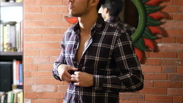 Young athletic man opening shirt on naked muscular pecs, abs and torso, undressing and taking it off