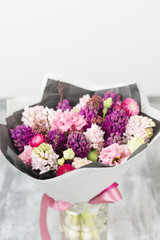 Bouquet of Beautiful violet and pink hyacinths. Spring flowers in vase on gray table background. bulbous plant