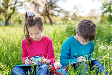 Two children are painted in the park. Guy and girl. Concept of education, education, childhood,...