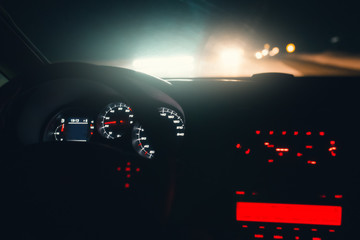 Driving car at night highway. Inside interior view. Illuminated dashboard