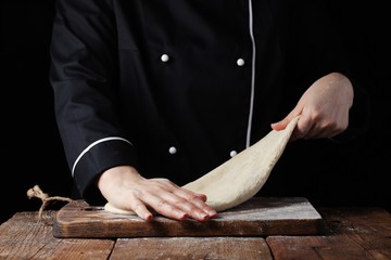 Chef kneading dough, Making dough by female hands at bakery on a black background