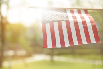 American flag with bokeh natural background and sunlight for Memorial Day or 4th of July.